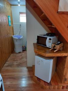 eine Mikrowelle auf einer Theke in einer Küche in der Unterkunft Sítio Cabanas da Lu in Canela + 74 Fotos