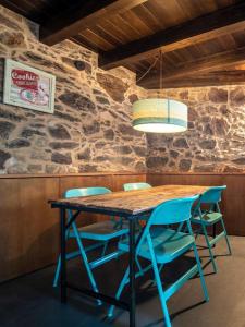 einen Tisch mit vier Stühlen und eine Lampe darüber in der Unterkunft Casa Peón de Pardaces in Santiago de Compostela