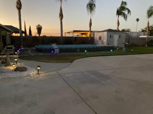 a driveway with palm trees and a house with a pool at My Oasis in Bakersfield