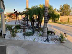 a landscaping with palm trees and a fountain on a street at My Oasis in Bakersfield
