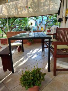 a table and a bench on a patio at Apartments by the sea Veli Iz, Iz - 18697 in Veli Iž