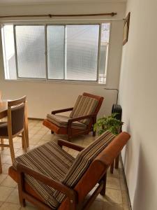 een kamer met stoelen, een tafel en ramen bij Departamento Garibaldi 239 in Mendoza