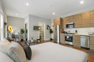 uma sala de estar com um sofá e uma cozinha em Modern Minimalist Studio Apt in Portage Park - Pensacola 3W em Chicago