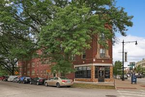 a red brick building with cars parked in front of it at Modern Minimalist Studio Apt in Portage Park - Pensacola 3W in Chicago
