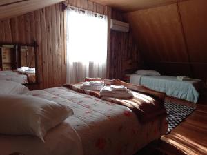 1 Schlafzimmer mit 2 Betten und einem Fenster mit Handtüchern in der Unterkunft Sítio Cabanas da Lu in Canela