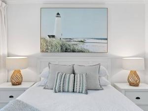 a bedroom with a bed with two lamps and a lighthouse at 3 BEDROOM CBD WATERFRONT LUXURY APARTMENT in Cairns +17 photos