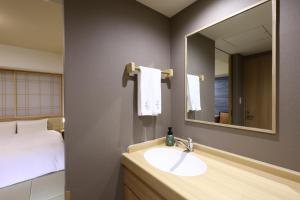 a bathroom with a sink and a mirror and a bed at Onyado Nono Sendai Natural Hot Spring in Sendai +37 photos