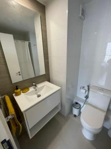 uma casa de banho com um lavatório, um WC e um espelho. em Departamento cercano a dunas y playa Concón em Concón