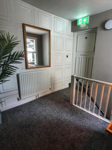 a hallway with a mirror and a stair case at The Coach and Horses in Hexham