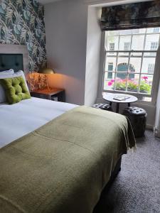 a bedroom with a large bed and a window at The Coach and Horses in Hexham