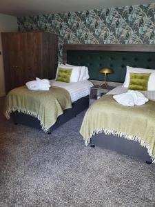 a hotel room with two beds with green walls at The Coach and Horses in Hexham
