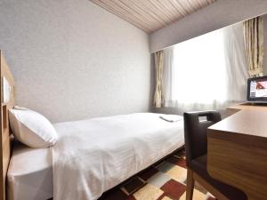 En eller flere senger på et rom på Hotel WBF Kushiro