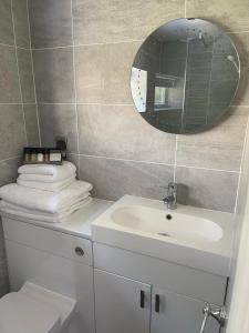 a bathroom with a sink and a mirror and a toilet at Bracken Lodge in Brighouse