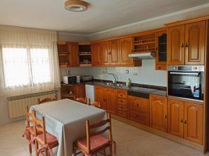 a kitchen with wooden cabinets and a table with chairs at Casa Patrick in Beceite