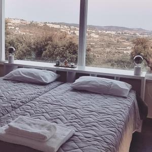 a bedroom with a bed with pillows and a large window at Herdade do Montinho in Portalegre