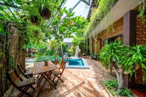 een binnenplaats met tafels en stoelen en een zwembad bij Olala An Bang Villa in An Bàn (2)