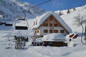 a ski lodge with a ski lift in the snow at Baita Goles in Sùtrio