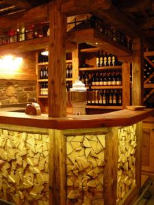 un bar de madera con un montón de botellas de vino en Baita Goles, en Sutrio