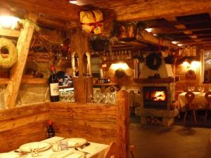 a dining room with a table and a fireplace at Baita Goles in Sùtrio