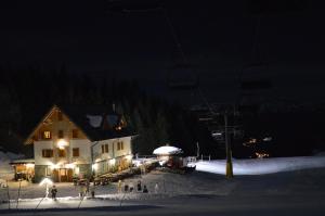 um alojamento de esqui à noite com um teleférico em Baita Goles em Sùtrio