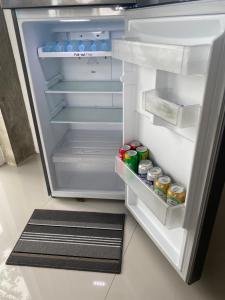 an open refrigerator filled with drinks and soda cans at Casa De Pueblo Japanese Shrine Unit 2 in Valencia