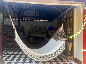 a hammock hanging in a room with a checkered floor at Red Palms in Blahbatu