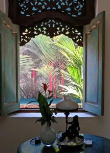 een raam met uitzicht op een palmboom bij Red Palms in Blahbatu