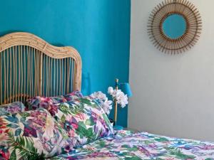 een slaapkamer met een bed met een bloemdekbed en een spiegel bij Red Palms in Blahbatu