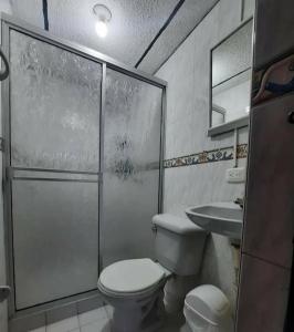 uma casa de banho com um chuveiro, um WC e um lavatório. em APARTAMENTO CON VISTA A LAS MONTAÑAS CAPACIDAD 6 PERSONAS SECTOR VILLAMARIA em Villamaría