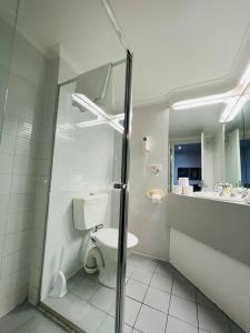 a white bathroom with a toilet and a shower at 408 Lovely one BR ex hotel ensuite room in city in Adelaide