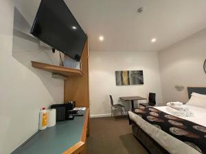 a hotel room with a bed and a flat screen tv at 408 Lovely one BR ex hotel ensuite room in city in Adelaide