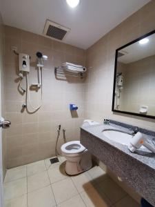 a bathroom with a toilet and a sink and a mirror at My Hotel Bukit Mertajam in Bukit Mertajam