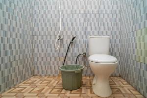 a bathroom with a toilet and a trash can at RedDoorz Syariah @ Jalan Bukit Kaminting 2 in Palangkaraya +26 photos