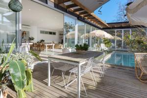 a patio with a table and chairs and a pool at Poolside Paradise Mount Eliza in Mount Eliza