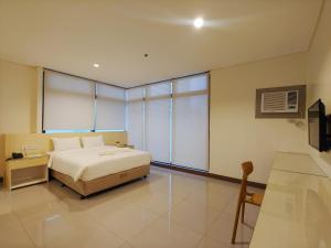 a bedroom with a bed and a large window at Kaizen Suites in Manila