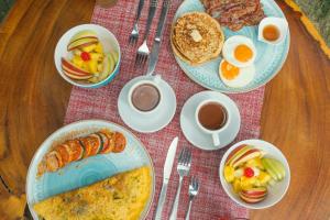 a table topped with plates of breakfast foods and coffee at Amāra Beach Eco Hotel in Dibulla