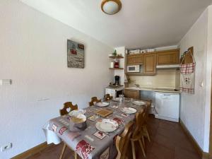 a kitchen with a table and chairs in a room at Appartement Praz-sur-Arly, 3 pièces, 7 personnes - FR-1-603-62 in Praz-sur-Arly