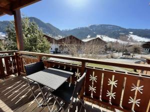 stół i krzesła na tarasie z pokrytymi śniegiem górami w obiekcie Appartement cosy avec piscine à 300m du lac de baignade, proche du village et des pistes - Praz-sur-Arly - FR-1-603-62 w mieście Praz-sur-Arly
