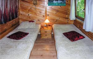 ノベ・バルプノにあるAwesome Home In Nowe Warpno With 3 Bedrooms And Wifiのログキャビン内のベッドルーム1室(ベッド2台付)