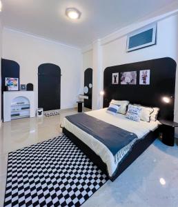 a bedroom with a large bed and a black and white rug at Bear Brick Villa in Da Lat