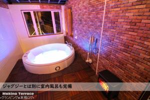 uma banheira na casa de banho com uma parede de tijolos em Roten Jacuzzi ・Morinoie in Metasequoia Namiki / Vacation STAY 3022 em Takashima