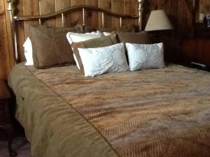 Una cama grande con varias almohadas encima. en Ocean's Breeze, 4/bed, 3/ba, Game Room. Sleeps 10! en Morro Bay