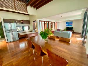 un ampio soggiorno con tavolo e sedie di Samet View Luxury Villa with Private Pool a Rayong