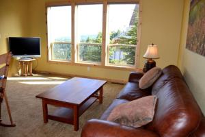 ein Wohnzimmer mit einer Ledercouch und einem Tisch in der Unterkunft 5bds/4.5baths & Incredible view in Truckee