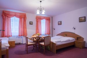 1 dormitorio con mesa, cama, mesa y sillas en Pension Inge, en Vyšší Brod