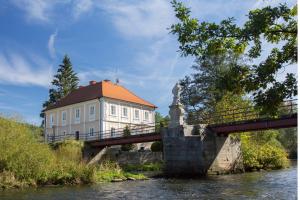 eine Brücke über einen Fluss mit einem Gebäude darauf in der Unterkunft Pension Inge in Vyšší Brod