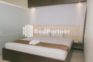 - une chambre avec un lit muni d'un panneau rouge partenaire dans l'établissement Pits Hotel Mitra RedDoorz near Atom Mall, à Gembong