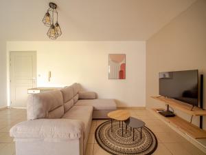 sala de estar con sofá y TV de pantalla plana en T2 - ARABESQUE - 45m² - 5min de l'aéroport, en Sainte-Marie