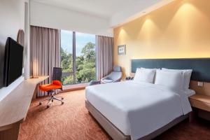 a hotel room with a large bed and a large window at Holiday Inn Express Kota Kinabalu City Centre, an IHG Hotel in Kota Kinabalu