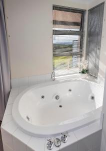 a white bath tub in a bathroom with a window at Seaview and Spa at Torbay in Albany
